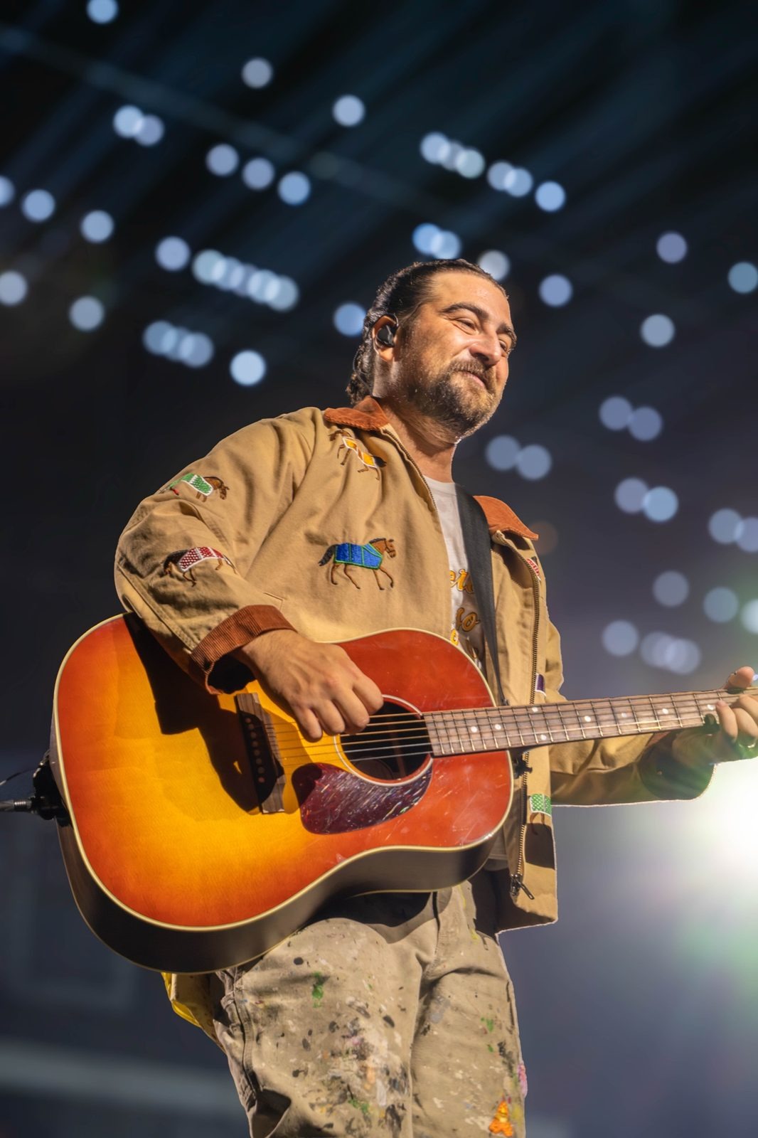Noah Kahan with a sunburst acoustic guitar