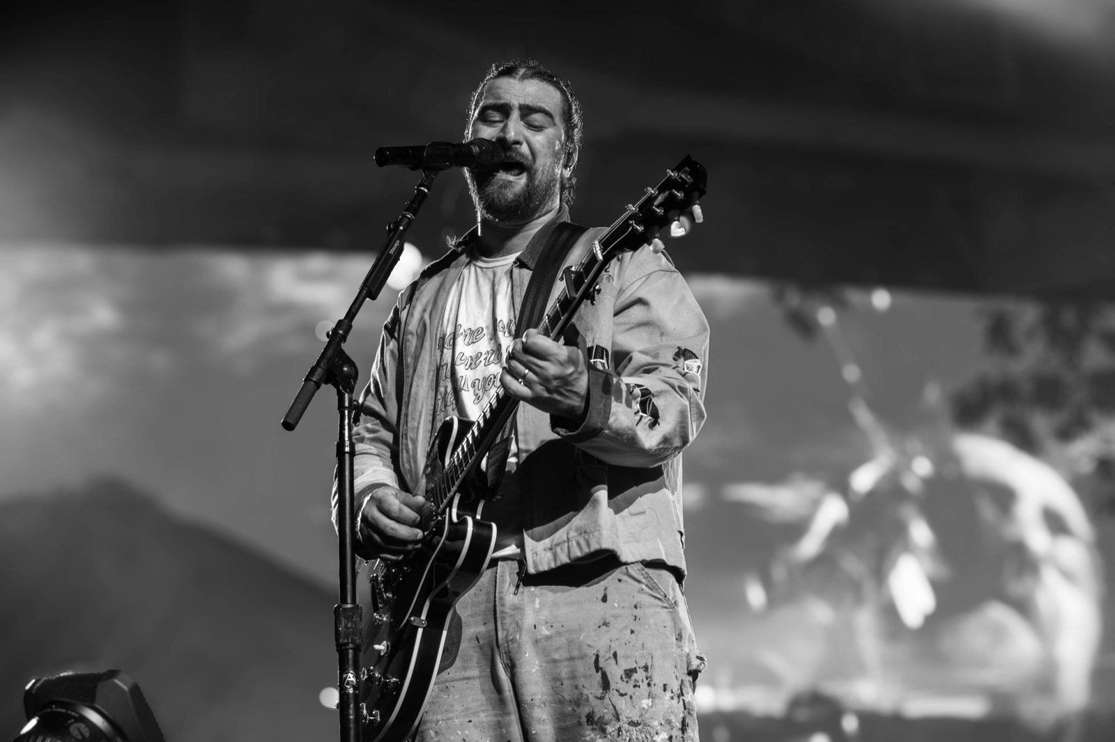 Black and white: Noah Kahan at the mic with an electric guitar