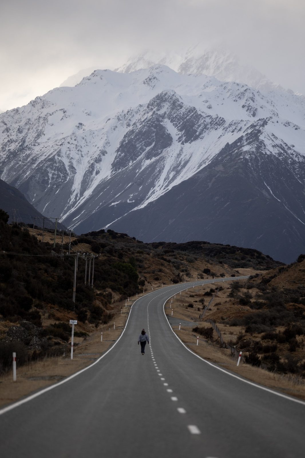 Long road running towards a snow-capped mountain